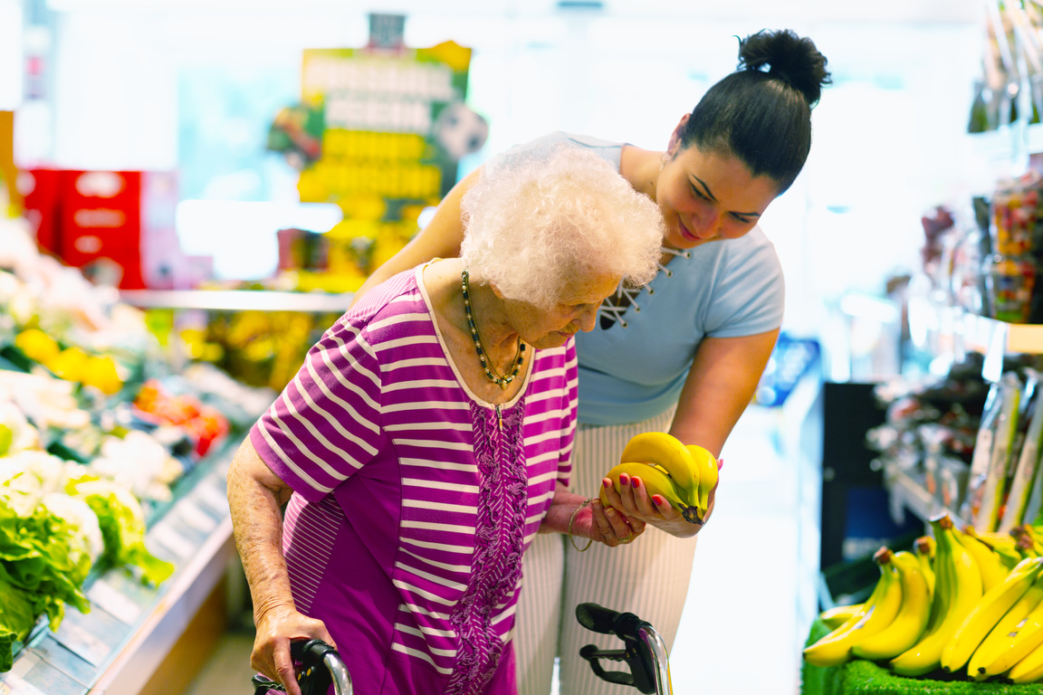 caregiver helping senior woman with shopping